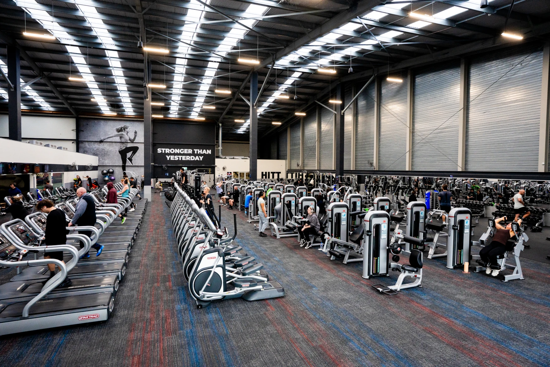 CityFitness gym floor with several different types of equipment and gym members working out